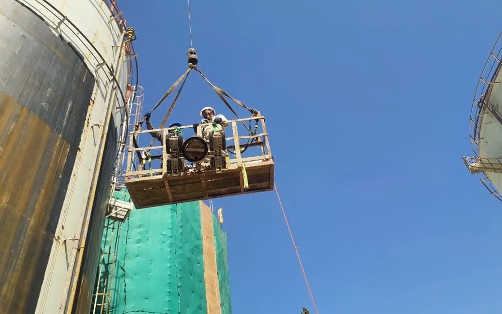 Robots lifted by crane basket to the tank shell